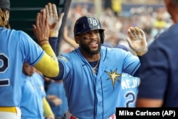 Yandy Díaz, de los Rays de Tampa, es felicitado por sus compañeros tras su cuadrangular de dos carreras ante los Bravos de Atlanta, el 9 de julio. (AP/Mike Carlson)