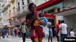 Una mujer transporta mercancías en una calle comercial en La Habana, Cuba, 16 de agosto de 2023. REUTERS/Alexandre Meneghini