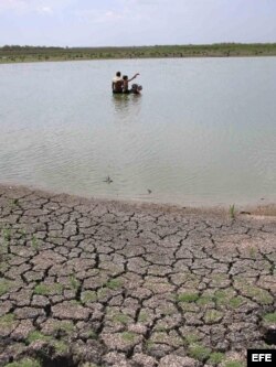 En esta foto del 2004 varias personas recojen agua en una de las presas abastecen a la oriental provincia de Holguín.