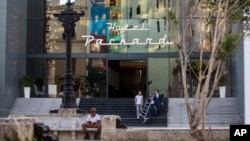 Trabajadores en la entrada del Hotel Packard. AP Photo/Desmond Boylan