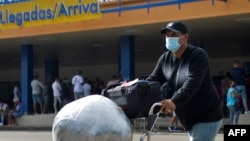 Un cubano residente en Estados Unidos arriba cargado de paquetes al Aeropuerto Internacional José Martí de La Habana. ( Yamil LAGE / AFP)