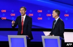 El ex congresista de Texas Beto O'Rourke (a la izquierda) y el ex gobernador de Colorado John Hickenlooper en un momento del debate del martes (Foto: AFP).