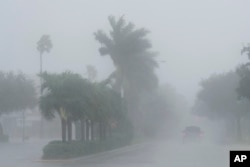 Un oficial del sheriff del condado de Lee patrulla las calles de Cape Coral, Florida, mientras caen fuertes lluvias antes del huracán Milton, el miércoles 9 de octubre de 2024. (Foto AP/Marta Lavandier)