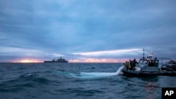 Imagen proporcionada por la Marina de Estados Unidos de marineros del Grupo 2 de Eliminación de Artefactos Explosivos recuperando restos de un globo espía en la costa de Myrtle Beach, Carolina del Sur, el 5 de febrero de 2023. (U.S. Navy vía AP)