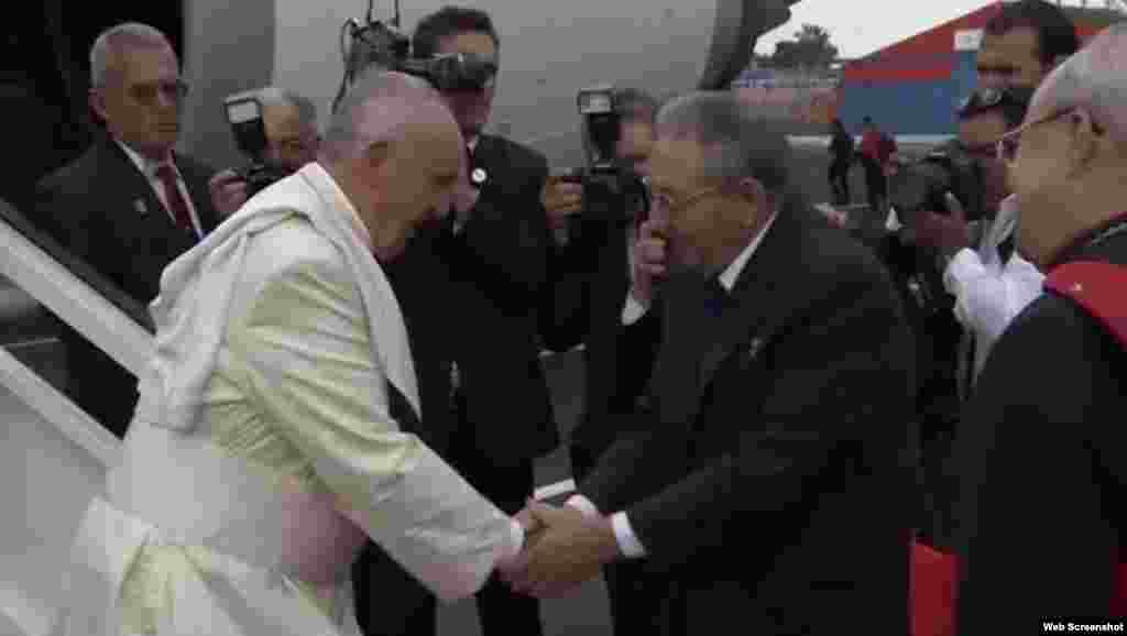 El papa Francisco (i) y el gobernante Raúl Castro (d) se estrechan las manos.