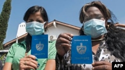 En esta foto, tomada a finales de abril, migrantes cubanas muestran sus pasaportes mientras protestan frente a la agencia de la ONU para refugiados en Costa Rica (Archivo/Ezequiel Becerra/AFP).