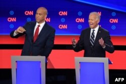 El ex vicepresidente Joe Biden (derecha) y el senador de Nueva Jersey Cory Booker en un momento del debate del miércoles en el Teatro Fox de Detroit (Foto: Jim Watson/AFP).