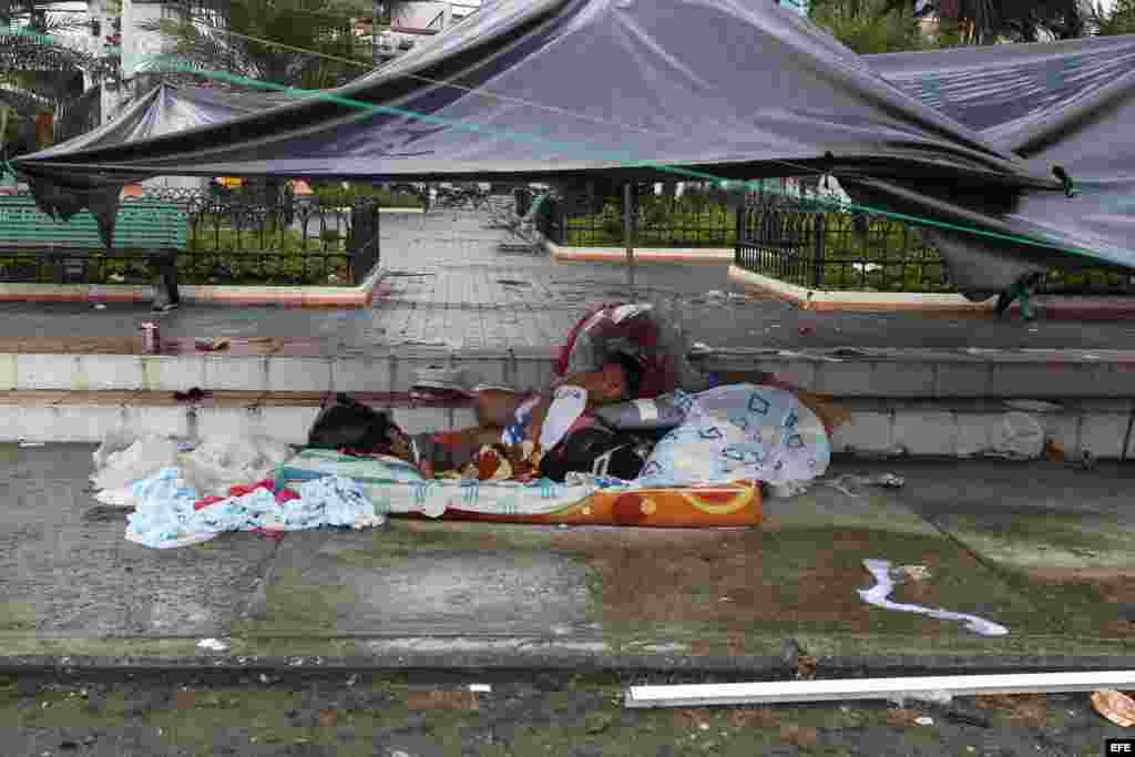 Una mujer y un niño descansan hoy Pedernales, localidad ecuatoriana afectada por el terremoto de 7.8 grados en la escala de Richter registrado el sábado.