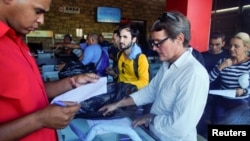 Clientes de una de las tiendas en dólares compran piezas para motocicletas en La Habana (Foto de Archivo-Alexandre Meneghini/Reuters).