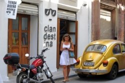 Una mujer camina frente a Clandestina, una tienda privada en La Habana.