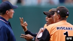 Fotografía de archivo. Víctor Mesa (c) es aguantado por el entrenador de lanzamiento de su equipo, mientras discute con el árbitro principal durante un juego en el estadio Latinoamericano de La Habana, Cuba.