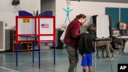 Kristen Matson vota con su hijo en la escuela primaria Lucy S. Herring el día de las elecciones, el martes 5 de noviembre de 2024, en Asheville, Carolina del Norte (Foto AP/Kathy Kmonicek)