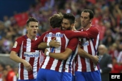 El delantero belga del Atlético de Madrid, Yannick Carrasco (2ºd), recibe la felicitación de sus compañeros tras marcar su tercer gol ante el Granada.