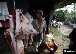 Campesinos venden carne de cerdo en una granja. REUTERS/Desmond Boylan