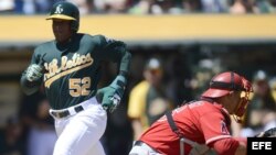 Yoenis Cespedes (i) de los Atléticos en acción durante un partido. 