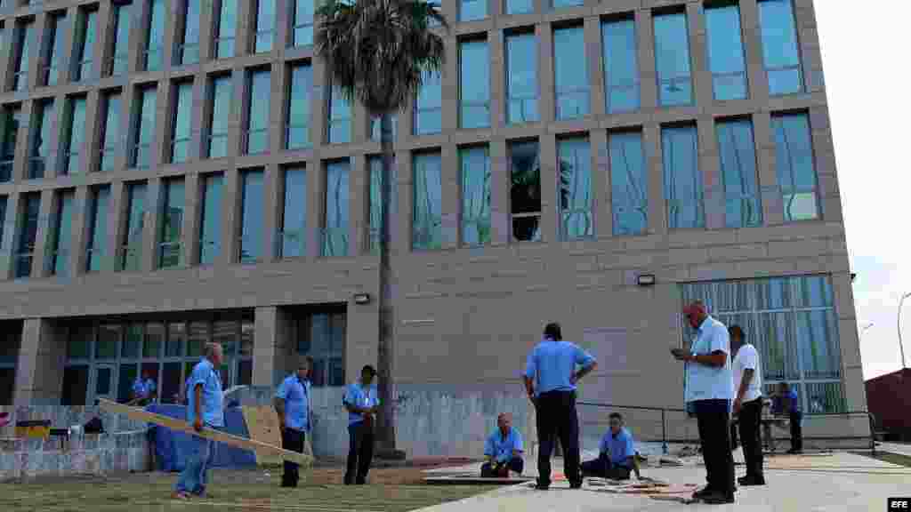 Varios obreros realizan labores constructivas para la ceremonia de izado de bandera en el jardín exterior del edificio frente al emblemático Malecón habanero (11 de agosto, 2015).