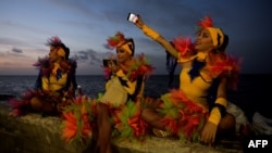 Bailarinas cubanos se fotografían con sus celulares. AFP/ Yamil Lage