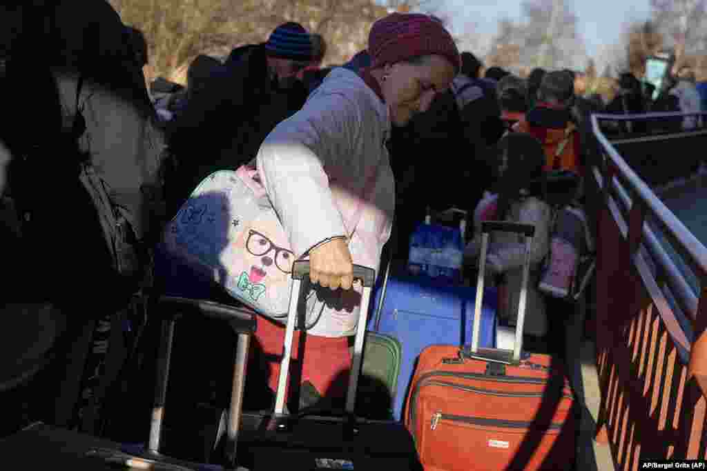 Una mujer espera en linea para abordar un tren de regreso a Ucrania. Las personas de Ucrania pueden cruzar la frontera múltiples veces para ayudar a la evacuación de refugiados, casi siempre menores. Foto: AP/Sergei Grits.