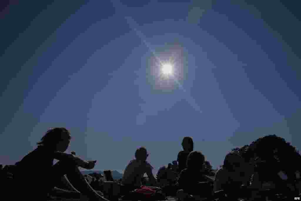 Varias personas disfrutan de los instantes antes de un eclipse solar en Rabun Gap, Georgia .