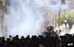 Tropas militares en vehículos blindados disparan gases lacrimógenos contra personas afuera del Palacio Quemado en la Plaza Murillo en La Paz el 26 de junio de 2024. AIZAR RALDES / AFP