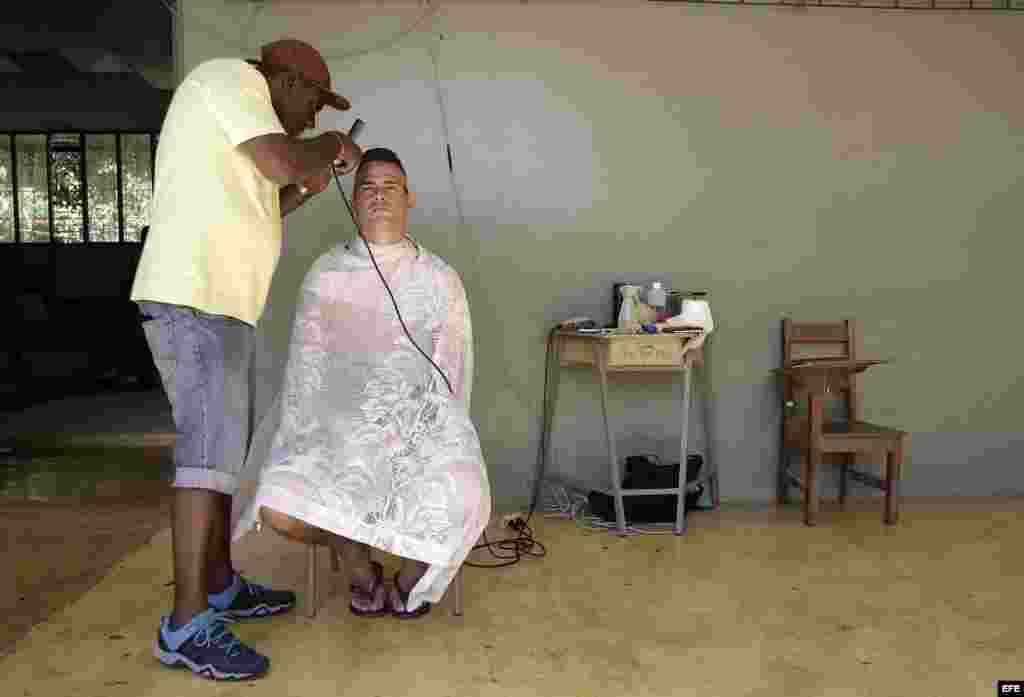 El cubano Alain Paula se corta el cabello horas antes de salir del país, en uno de los albergues ubicados en el pueblo de La Cruz, Costa Rica. EFE